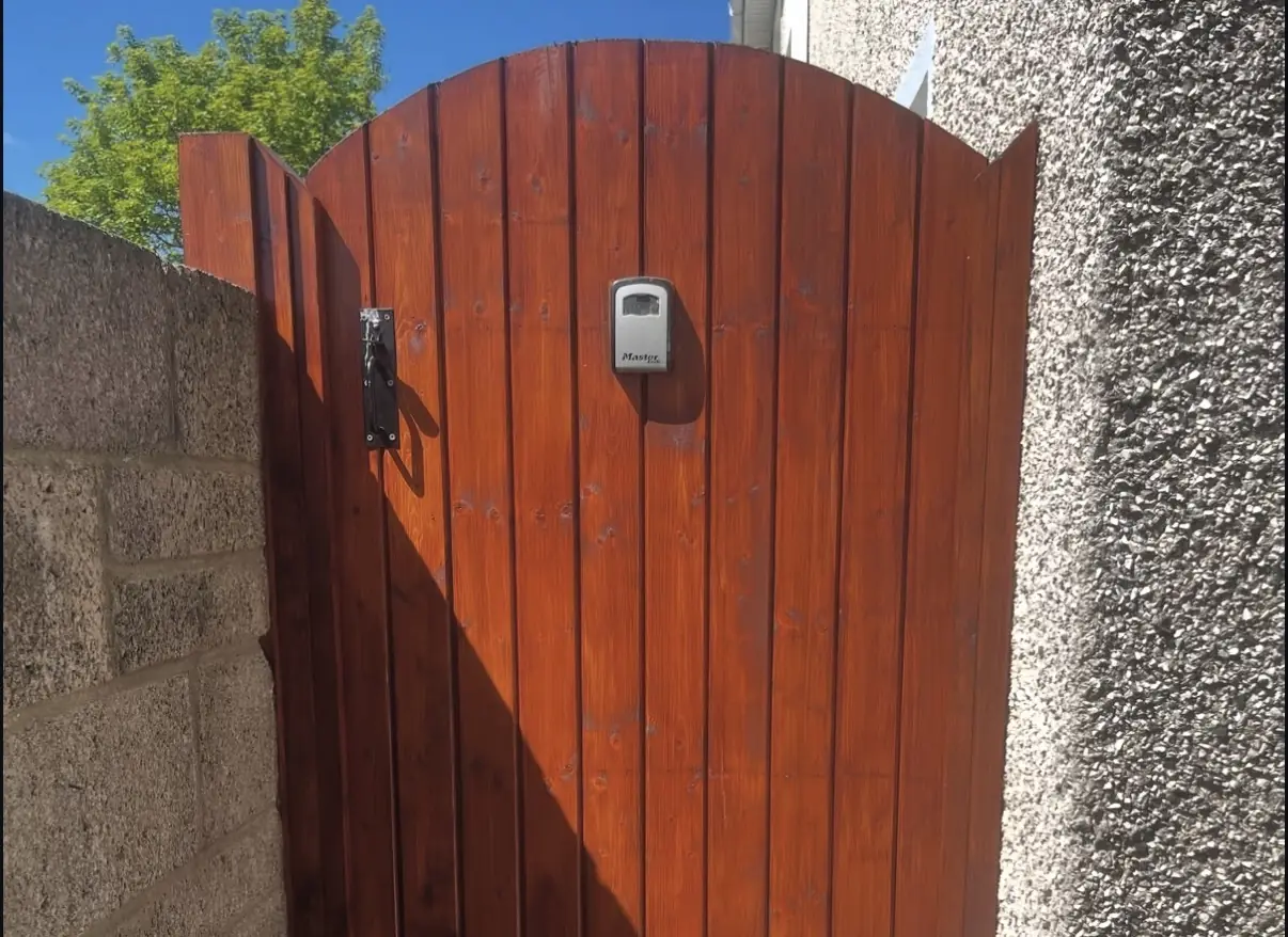 Freshly varnished wooden side gate with rich mahogany finish
