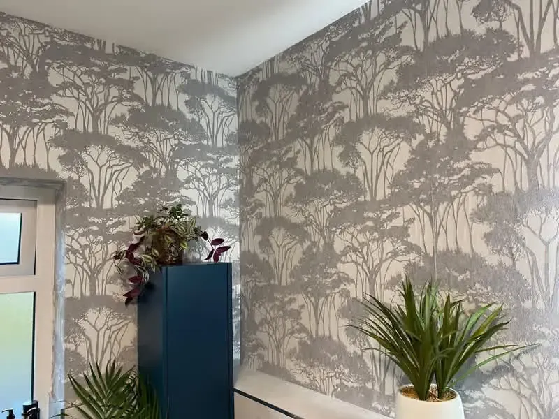 Feature wall with tree-motif wallpaper in soft grey, professionally hung by Painter AG