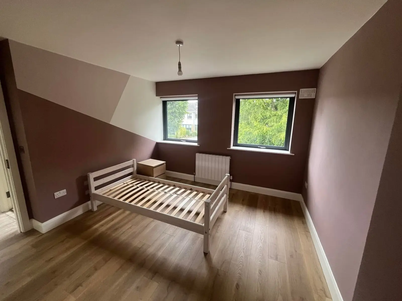 Bedroom painted in a soft mauve with crisp white trim