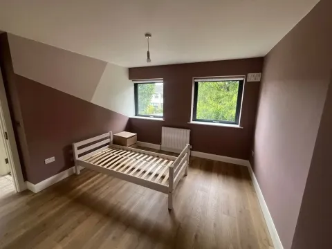 Bedroom painted in deep mauve with cream ceiling