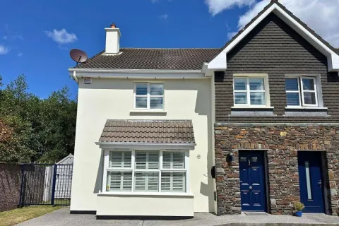 House exterior repainted in cream with white window trim