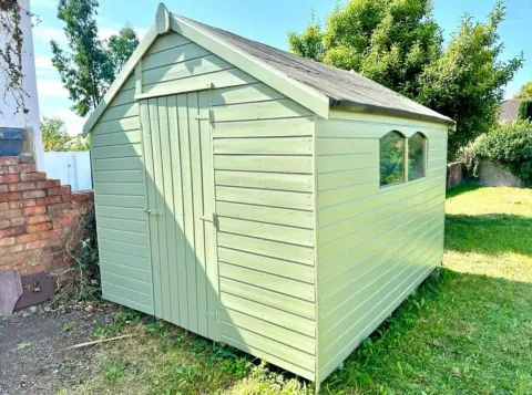 Garden shed painted in soft sage green