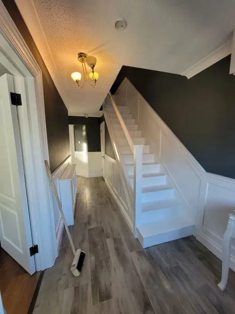 Hallway and stairs with charcoal walls and white wainscoting
