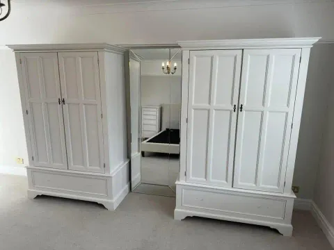 Hand-painted white wardrobes in a bedroom