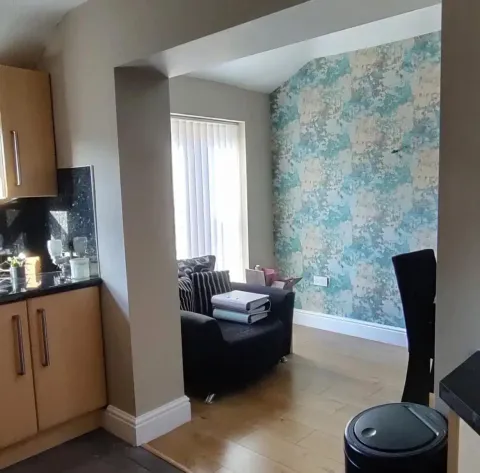 Dining nook accent wall in teal and cream textured wallpaper