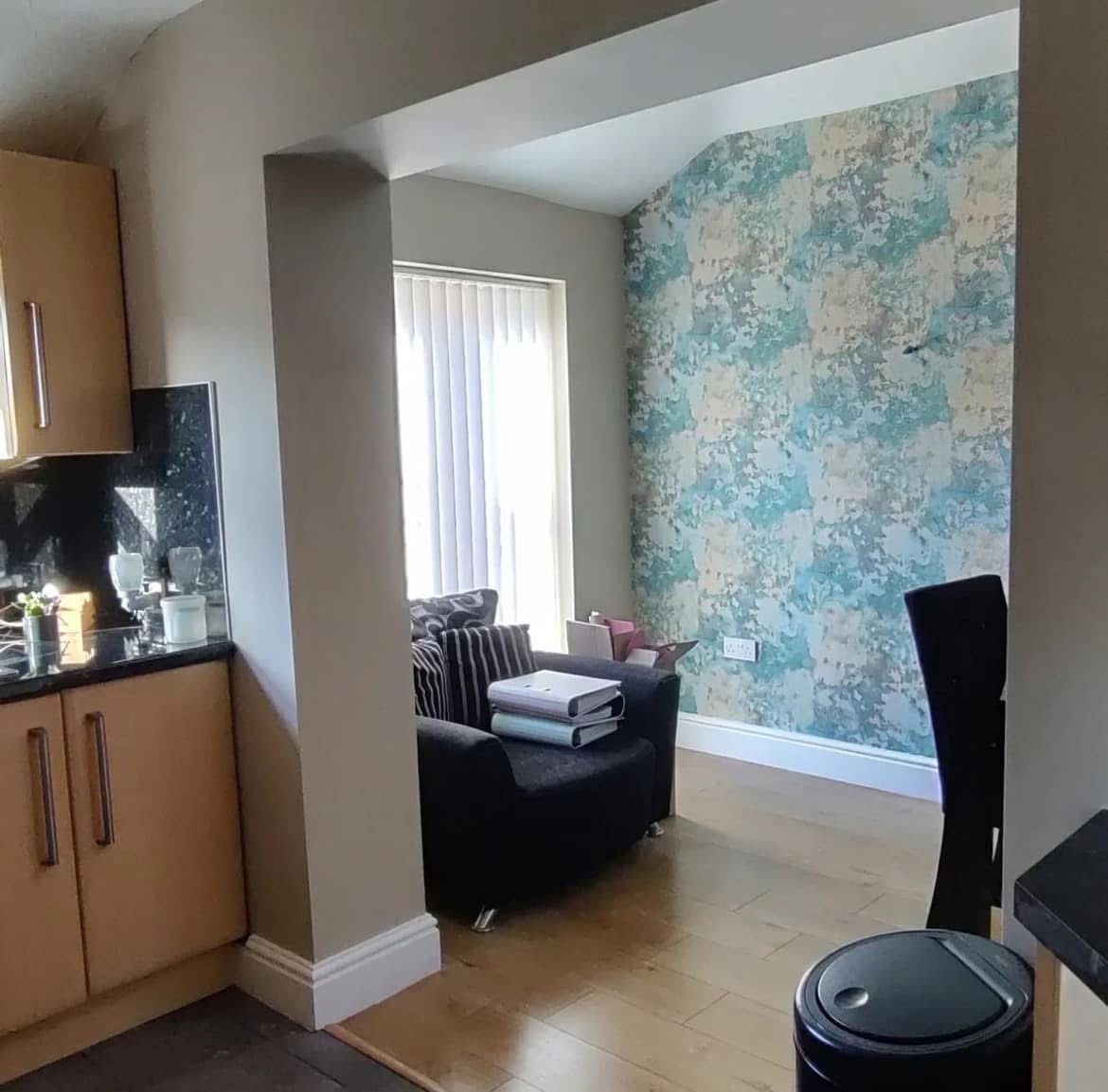 Dining nook accent wall in teal and cream textured wallpaper